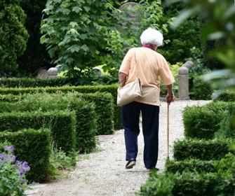 Ældre kvinde går tur på kirkegård