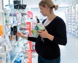 Gravid kvinde vælger varer på apoteket