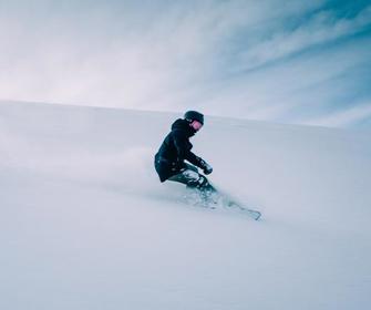 Barn står på snowboard