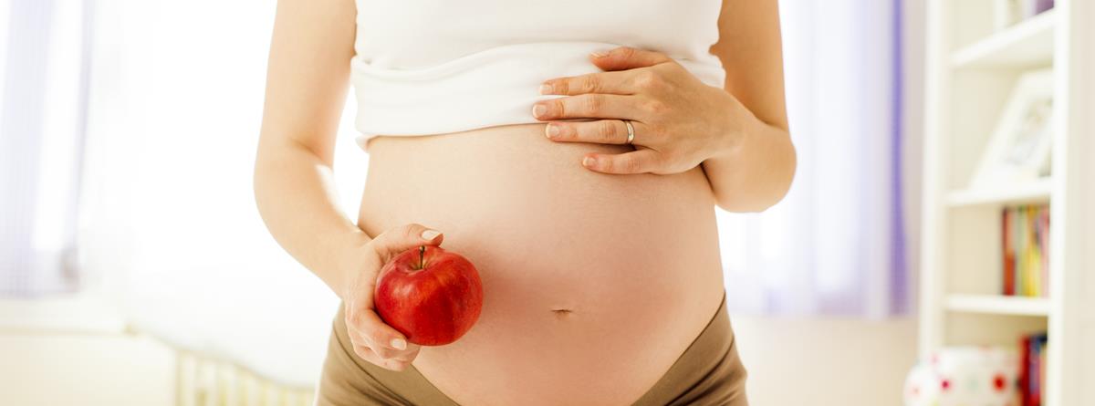 Gravid kvinde med æble i hånden