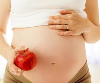 Gravid kvinde med æble i hånden