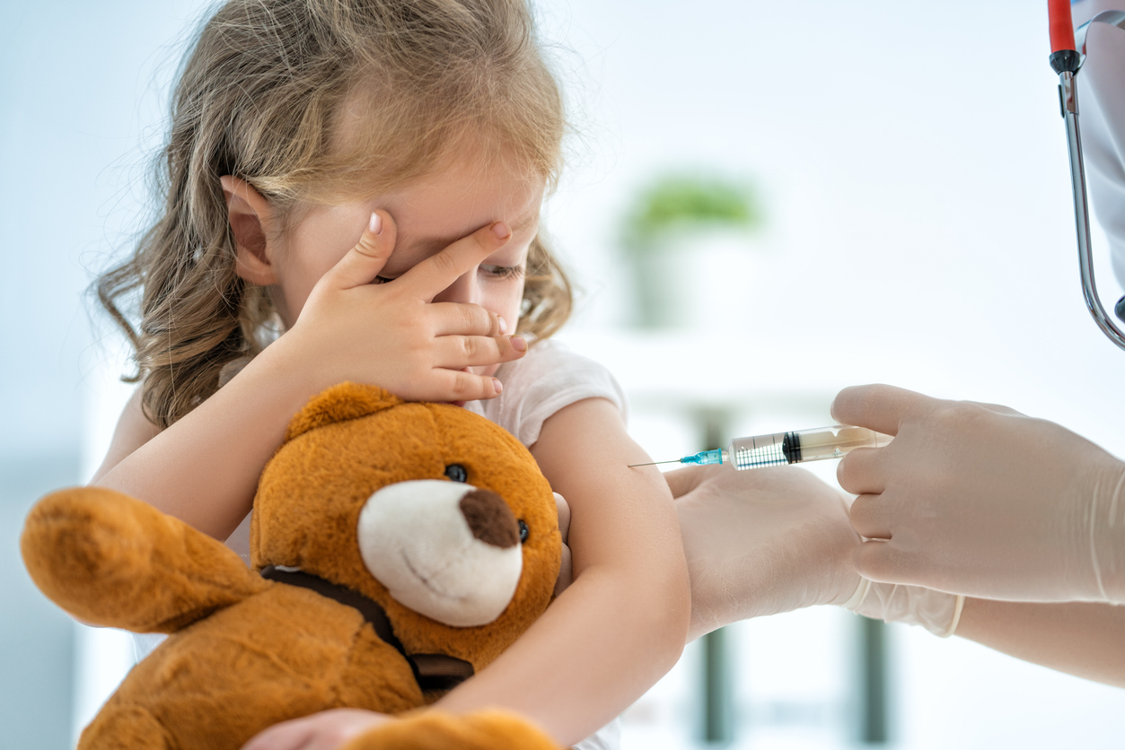 Pige med bamse bliver vaccineret
