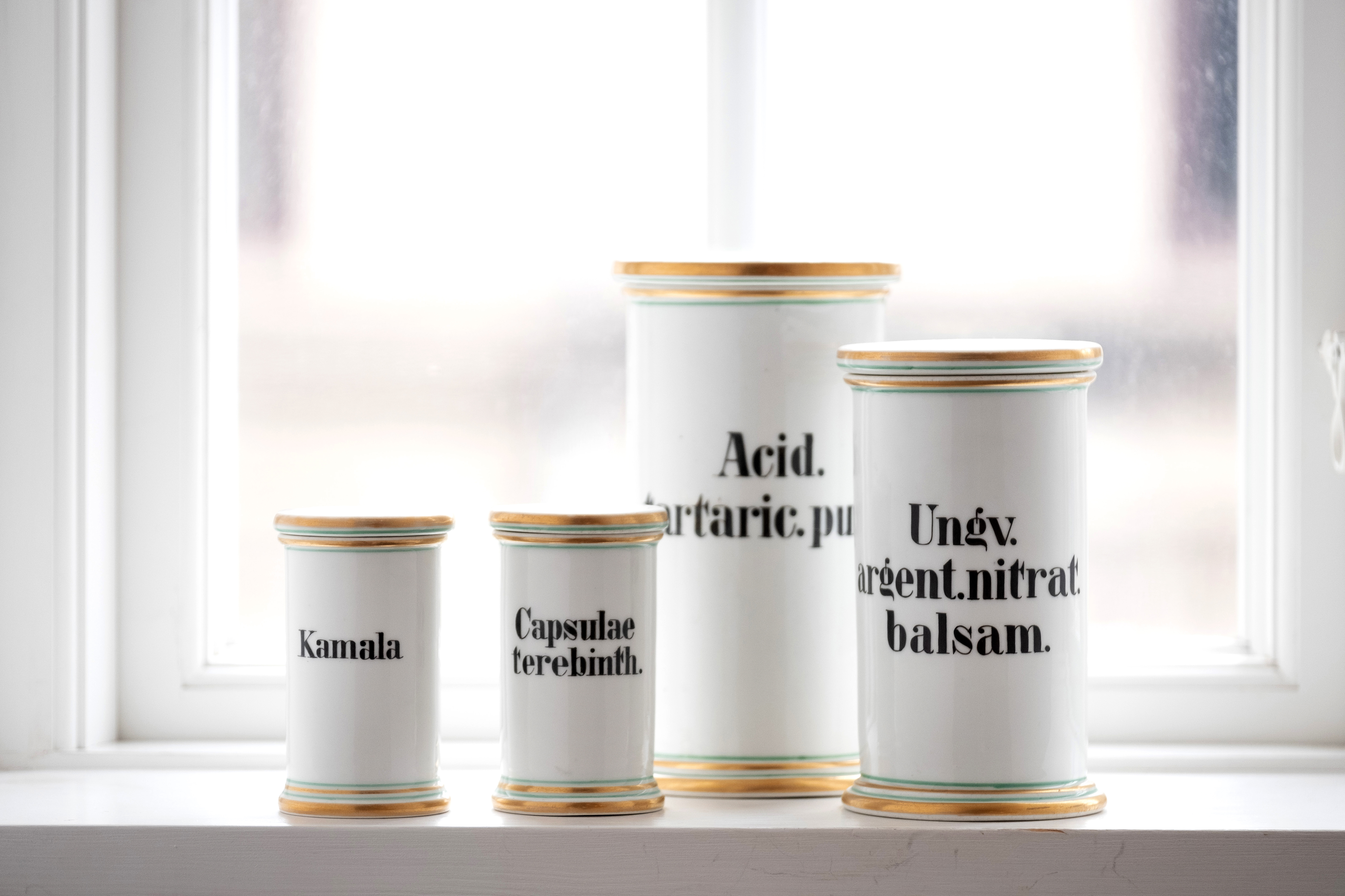 Historiske medicinkrukker placeret i vindue